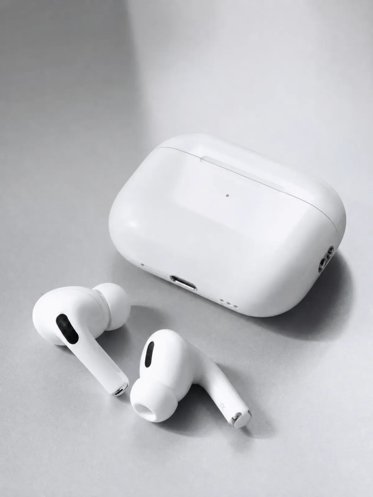 Independent ecommerce concept featuring Apple AirPods Pro and their charging case on a silver-white surface.